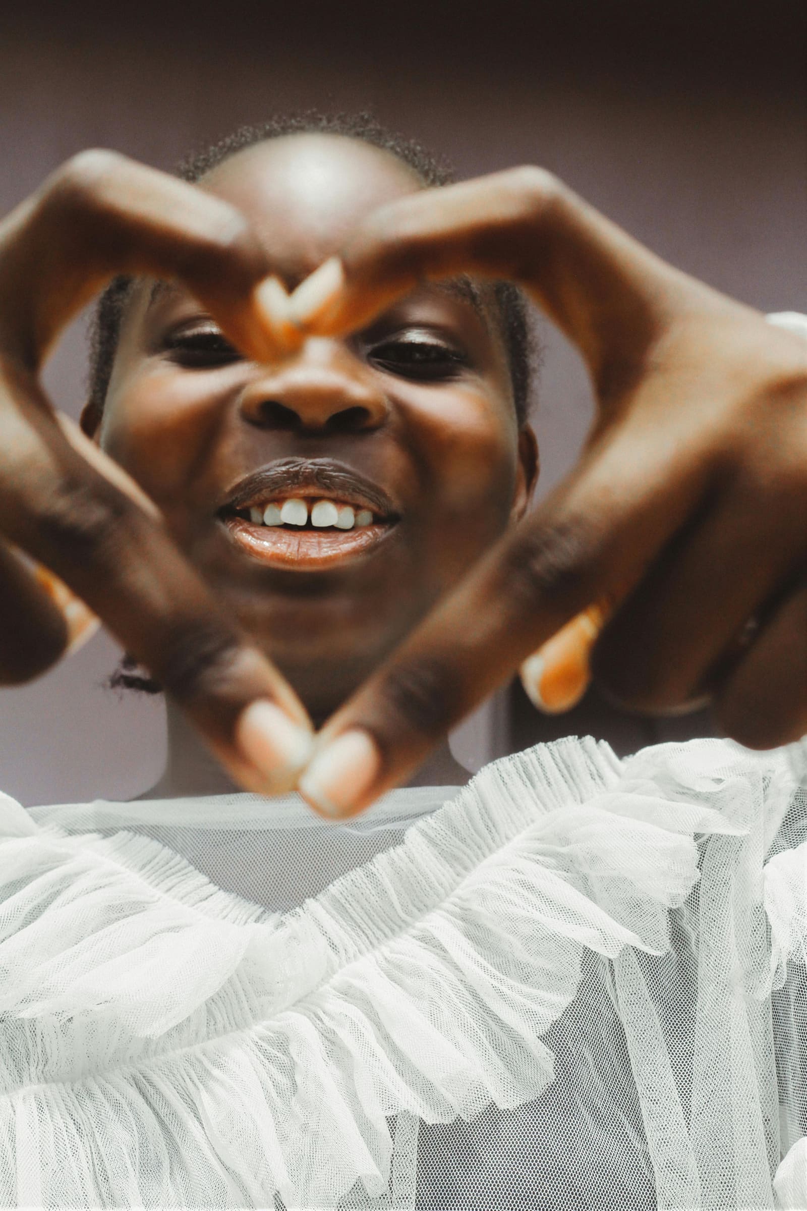 Child forming a heart shape with their hands