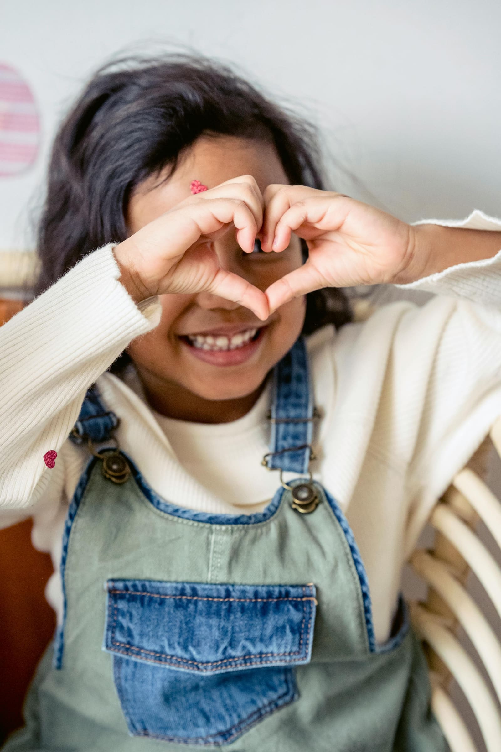Young girl forming a heart shape with her hands
