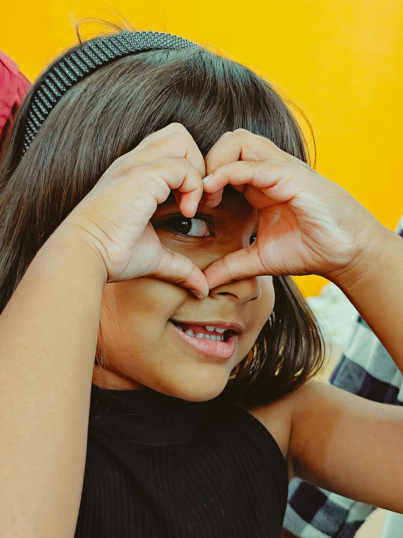 Young girl forming a heart shape with her hands
