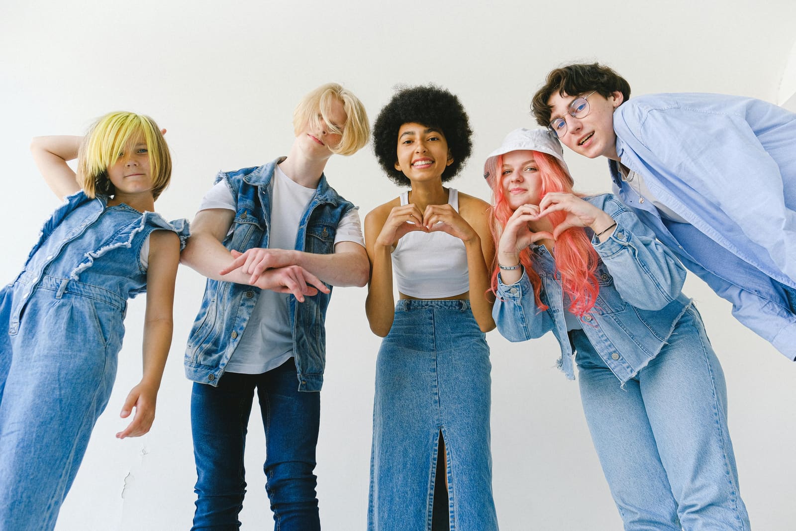 A diverse group of young people, two forming heart shapes with their hands