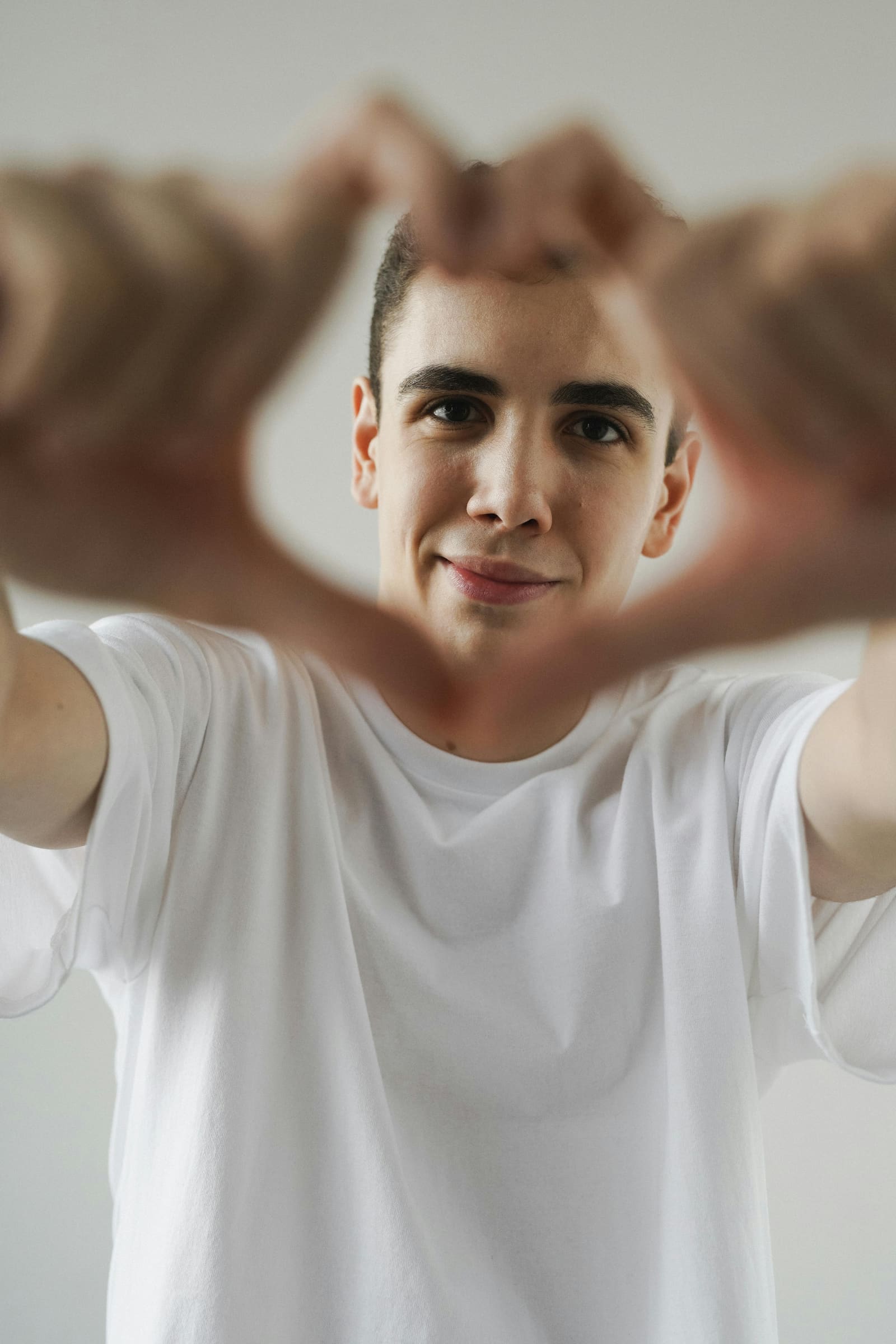 Young man forming a heart shape with his hands